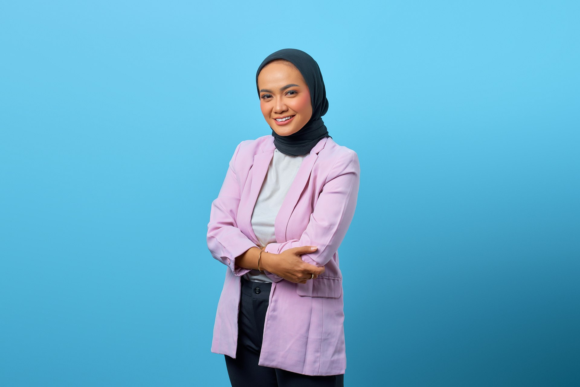 a woman standing with her arms crossed and smiling